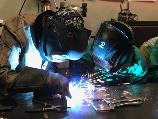 Welding students grinding a project