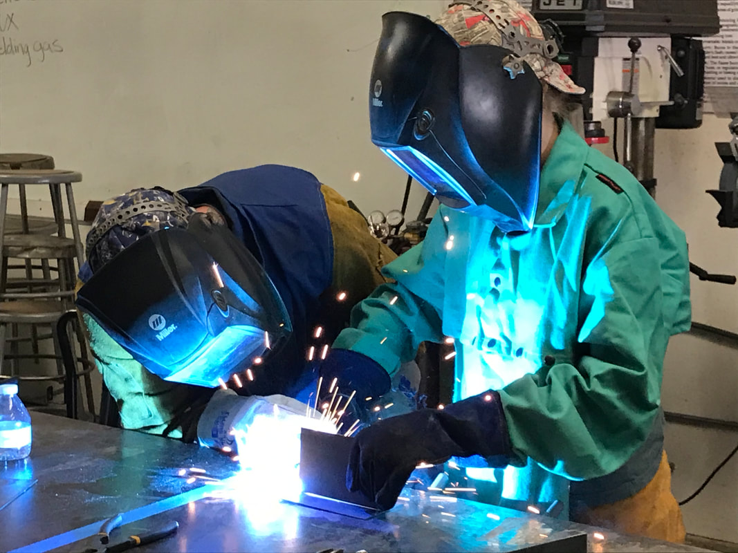 Two students learn to weld in our Welding Camp.